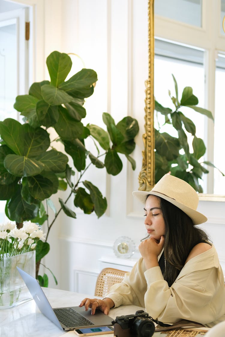 Woman In Hat Sitting And Working On Laptop 