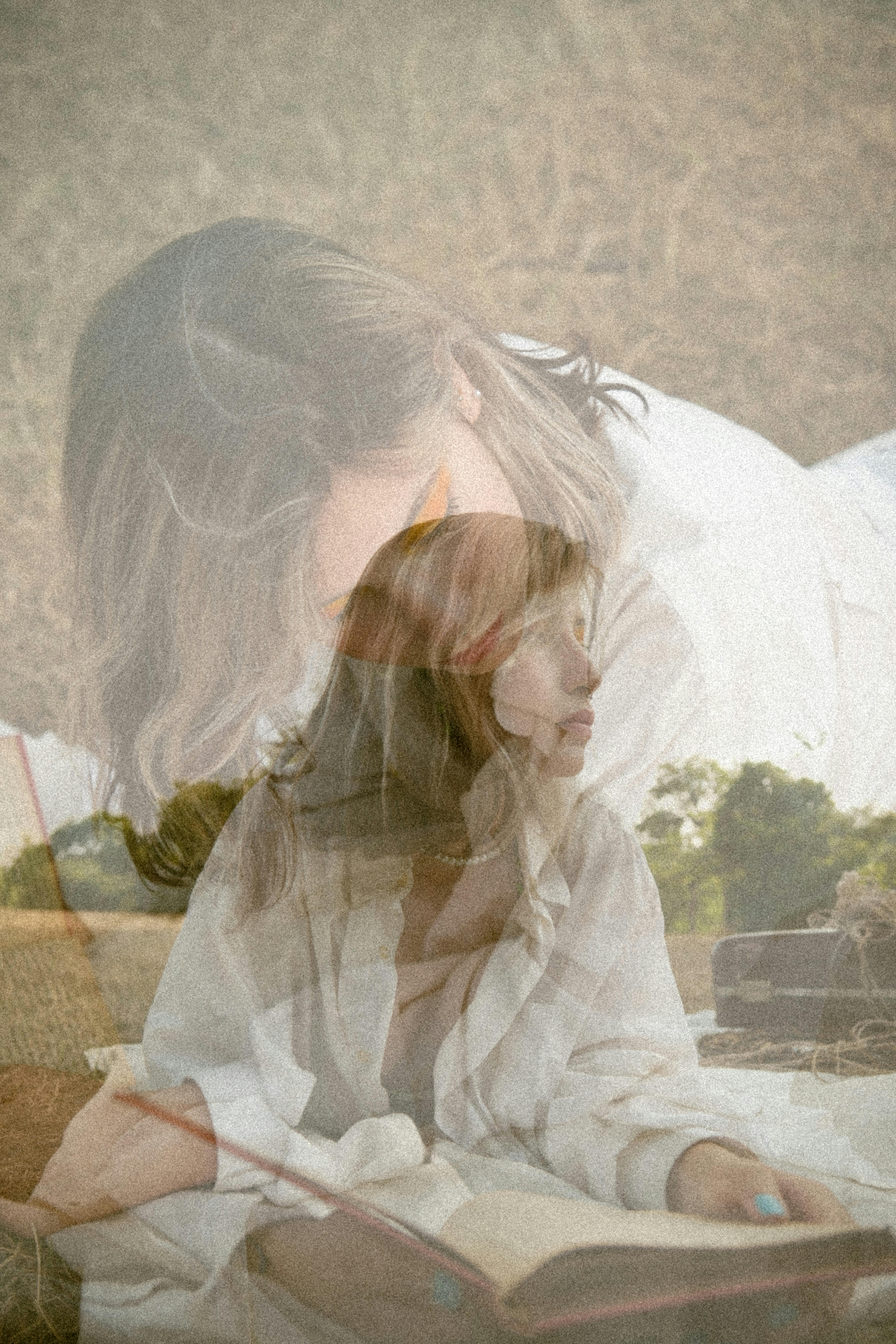 Double exposure of a woman reading in a serene outdoor setting, creating an artistic and rustic feel.