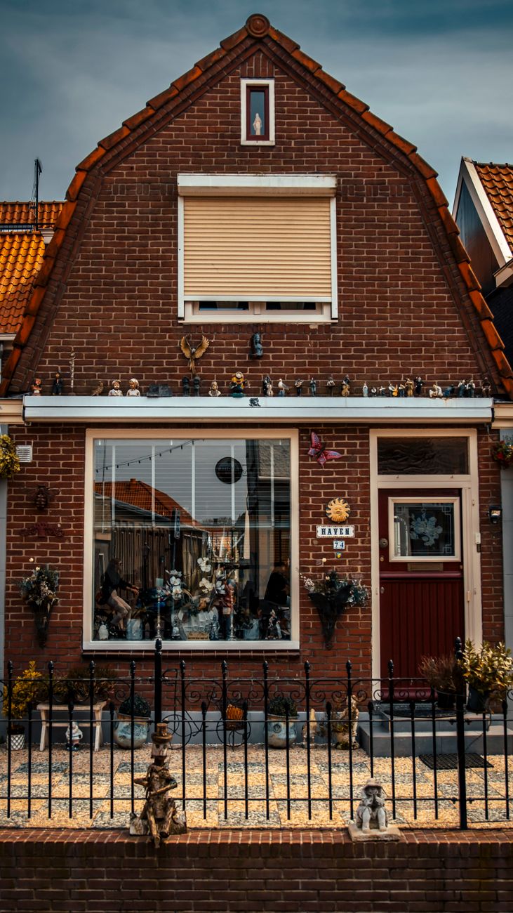 Buitenkant van een charmant bakstenen huisje in Volendam, Nederland, dat traditionele architectuur toont.