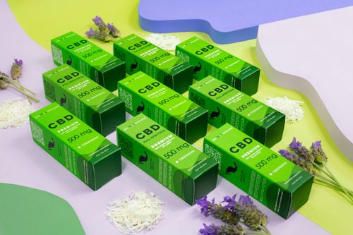 Free Colorful flat lay of CBD oil boxes with lavender flowers and rice, promoting natural wellness. Stock Photo