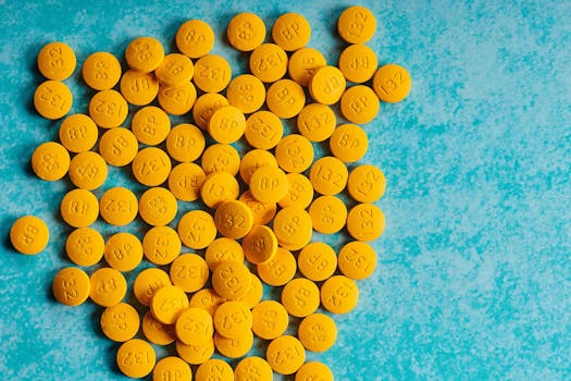 Bright yellow pills scattered on a vibrant blue background, resembling a healthcare theme.