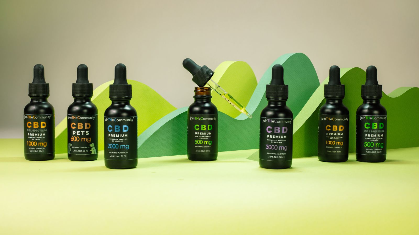 Array of CBD oil bottles with varied dosages on a green backdrop, ideal for wellness themes.