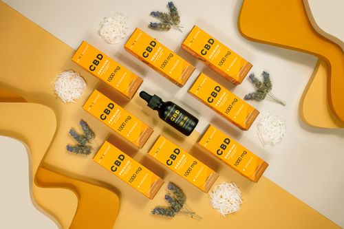 Free Flat lay of CBD boxes and vials with lavender on a yellow background, perfect for wellness themes. Stock Photo