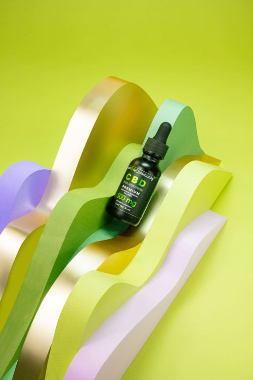 Free A CBD serum bottle creatively placed on a wavy colorful background, offering a vibrant aesthetic. Stock Photo