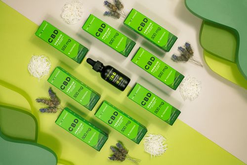 Free Flat lay of CBD oil packaging surrounded by lavender on a green background. Stock Photo
