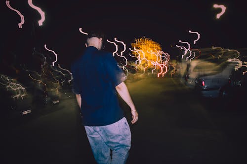 Blurred Cars and Lights behind Man