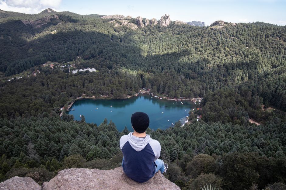 Unbeatable Yaxmuul and the Cenotes of the Mayan Underworld Review: An Unforgettable Journey Into Sacred Mayan Waters Review 2026 - Man overlooking breathtaking lake and forest from rock edge in Mineral del Chico, Mexico.