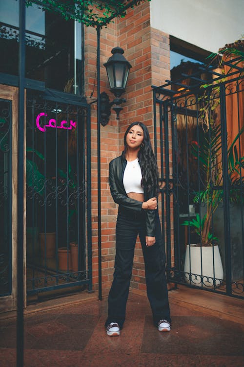 Young Brunette Woman in Black Leather Jacket and Cargo Pants Posing on a Street