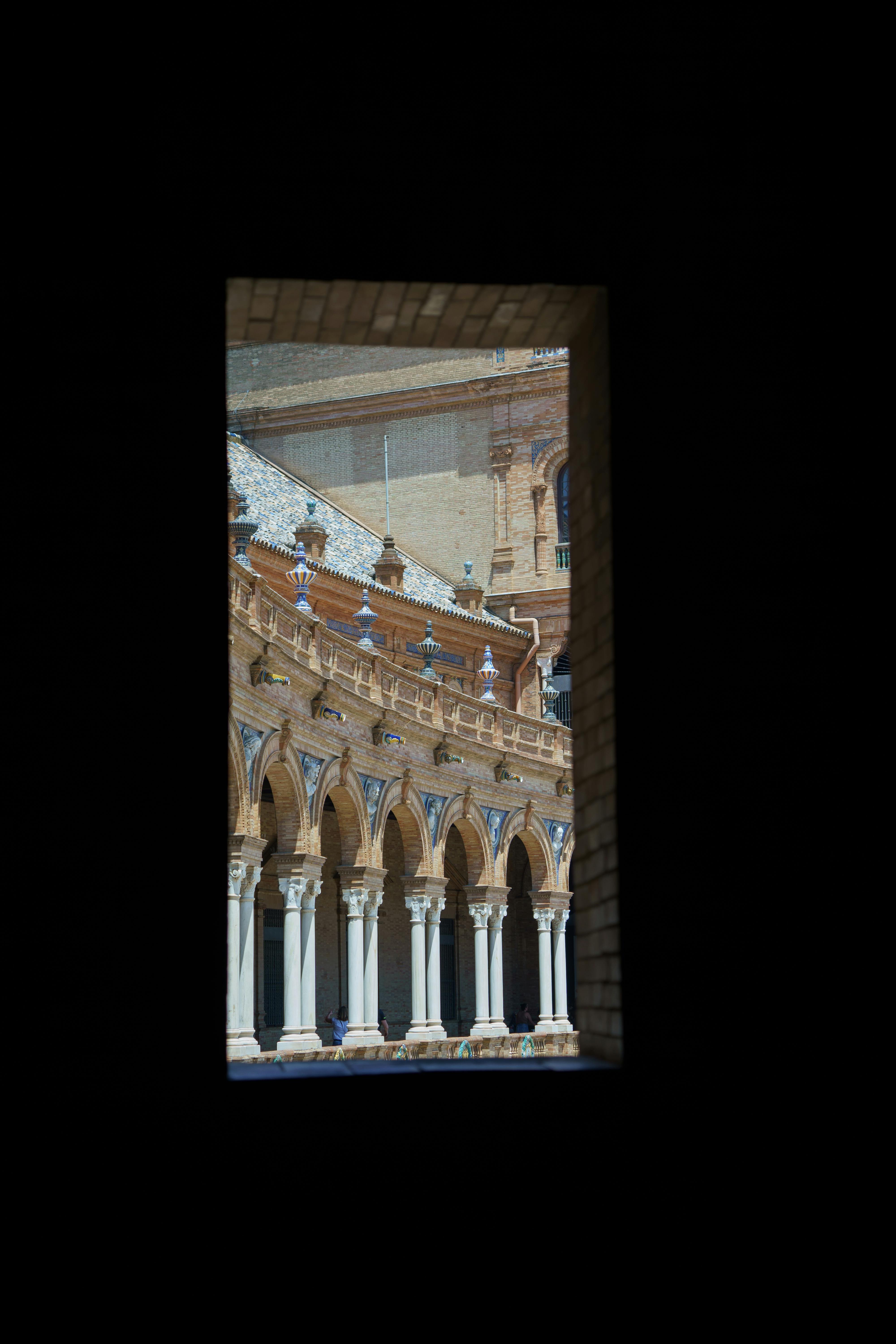 arched gallery of a palace at plaza de espana seen from a window seville spain