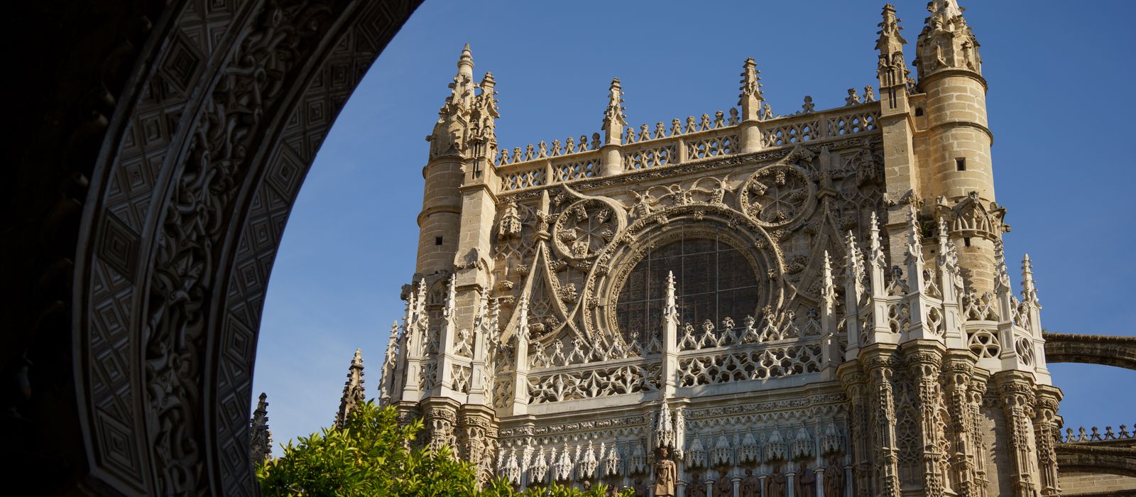 Explore the intricate gothic architecture of Seville Cathedral's facade with its stunning details.