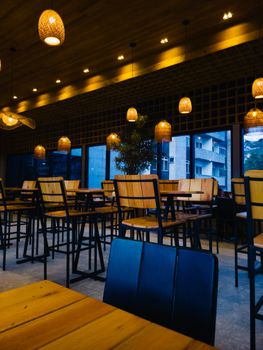 Warm and inviting cafe interior featuring high chairs, wooden tables, and stylish lamps.