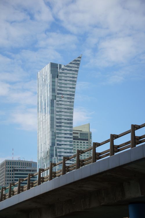 Free Vertical shot of Warsaw's skyline featuring Złota 44 and urban bridge. Stock Photo