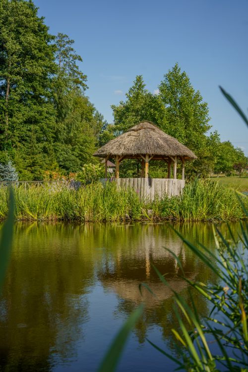 Free Peaceful lakeside gazebo surrounded by lush greenery in Dolistowo Nowe, Poland. Stock Photo