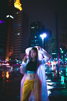 夜晚，在充满活力的城市街道上，一位穿着雨衣的亚洲女性留下了她的时尚肖像