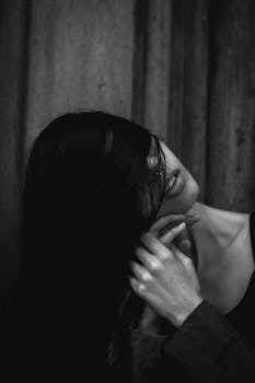 这是一幅黑白艺术肖像，画中女子的脸被头发遮住，营造出一种神秘感