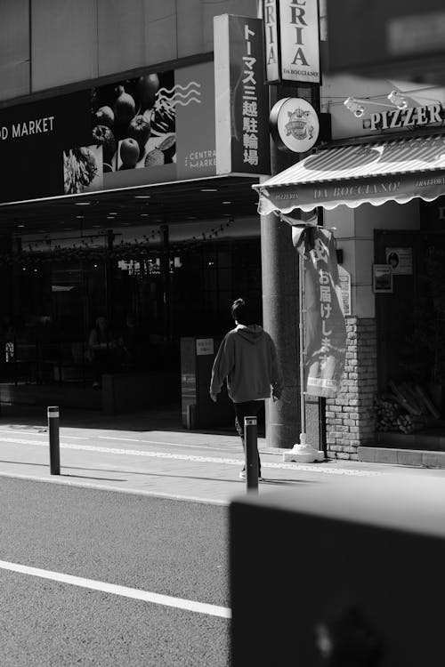 Man Walking on Sidewalk in Black and White · Free Stock Photo