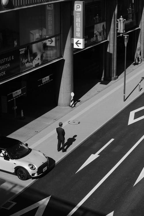 Man Standing on a Street in Black and White