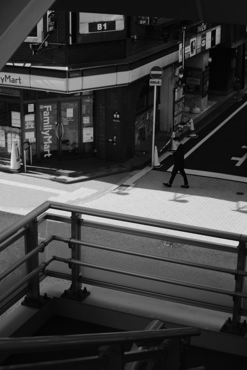 Free Black and white photo of an urban street with an overpass, reflecting a city scene. Stock Photo