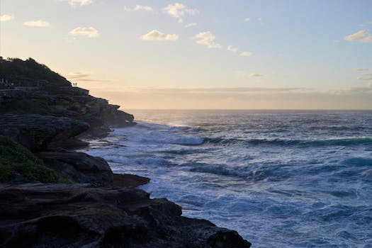 Experience tranquility with a coastal sunset over the rocky shoreline, evoking peace and wanderlust.