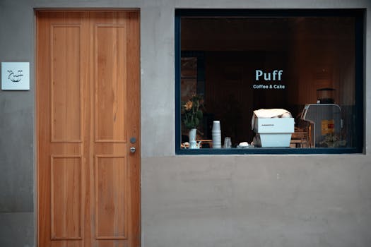 A modern cafe facade with a wooden door and a window displaying 'Puff Coffee & Cake' in Suzhou, China.