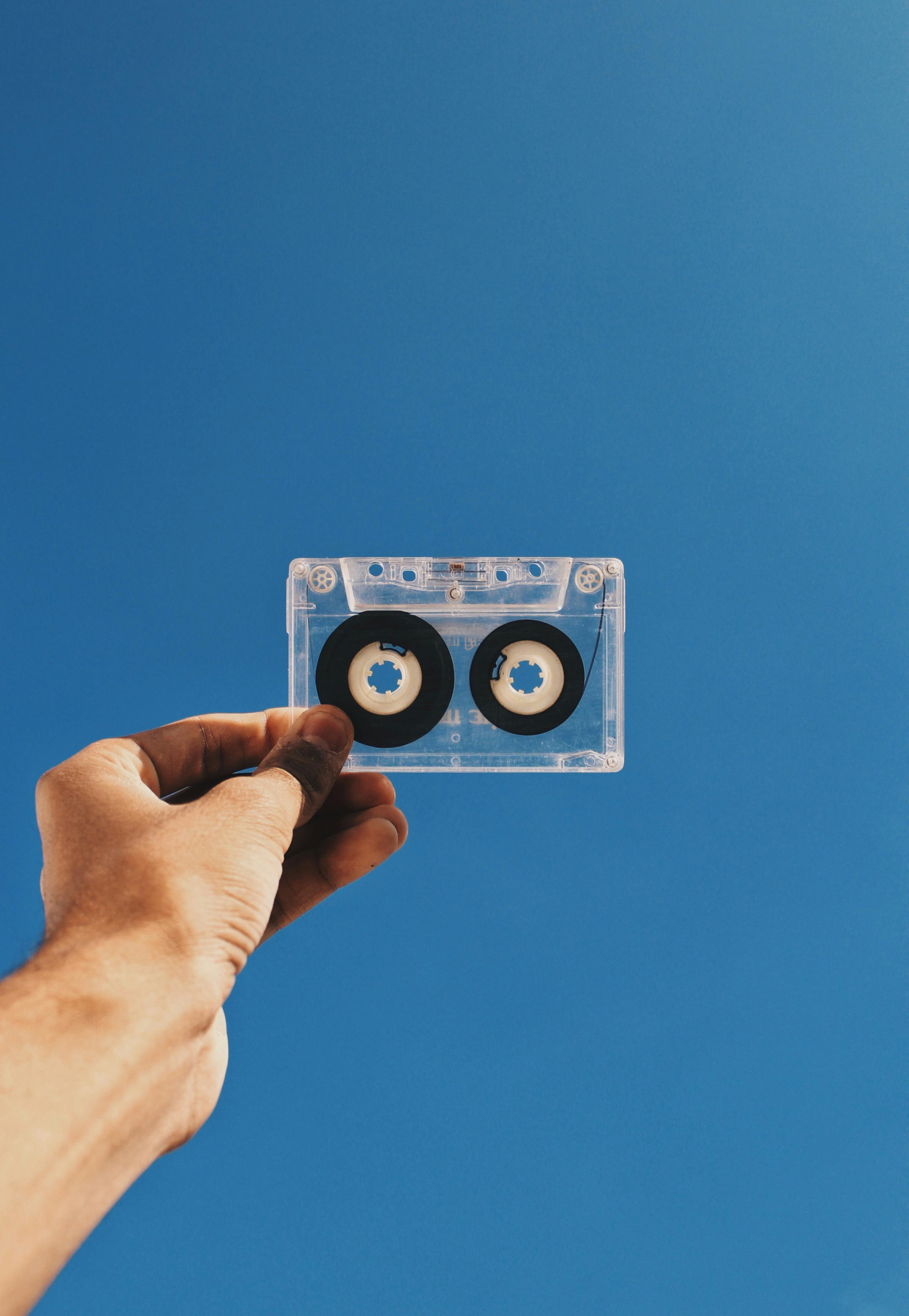 clear and black cassette tape on person s hand