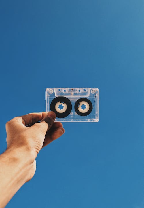 Free Clear and Black Cassette Tape on Person's Hand Stock Photo