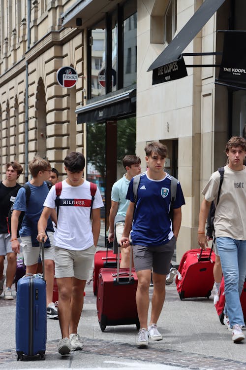 Young Men Walking in the City with Suitcases 