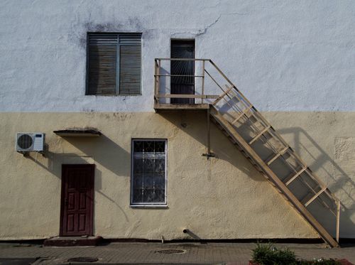 Free Sunlit facade featuring a staircase and windows in Vileika, Belarus. Stock Photo