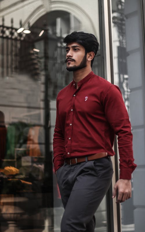 Uomo In Camicia Di Vestito Rossa Vicino Alla Parete