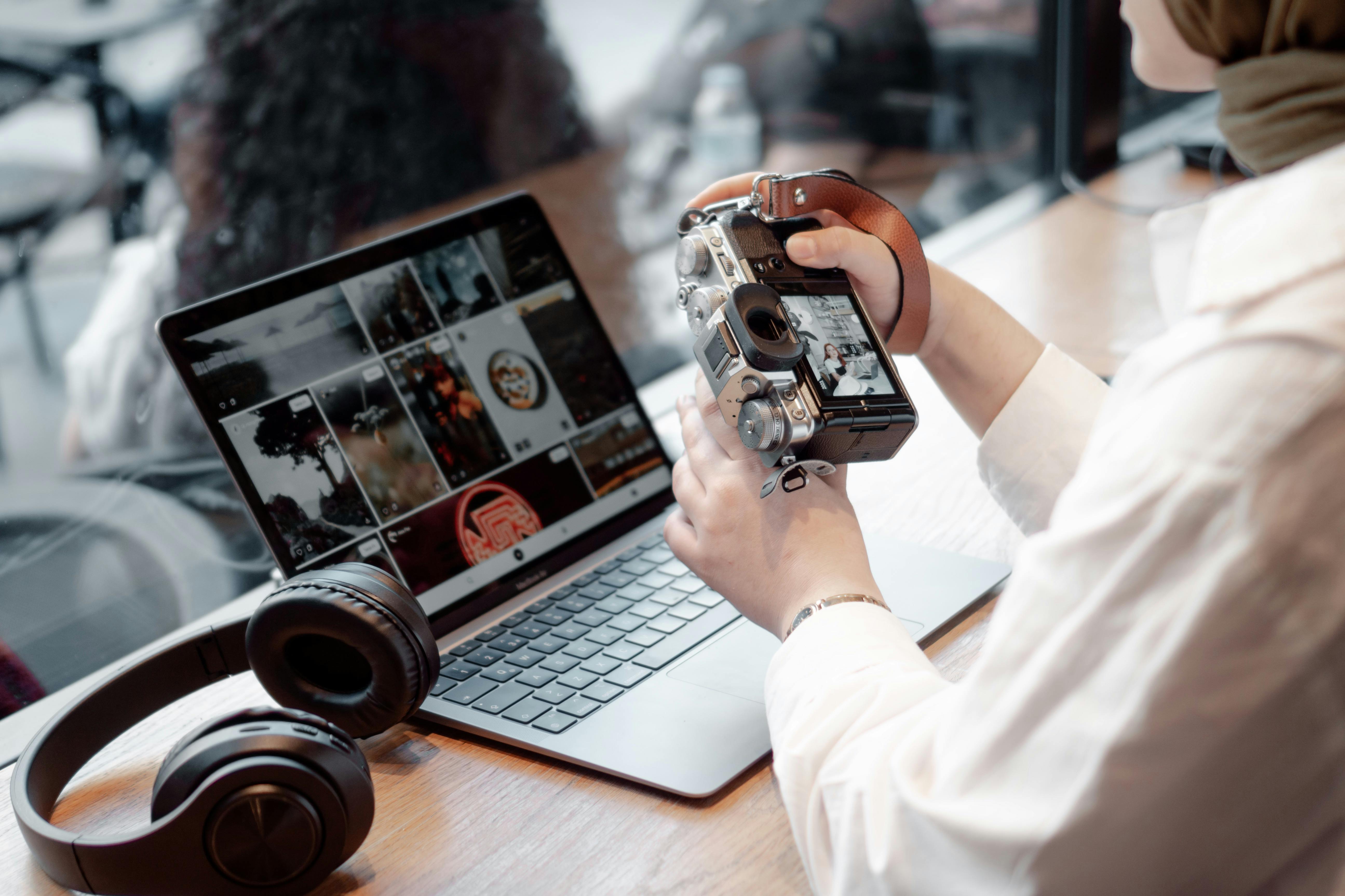A person using a camera and a laptop