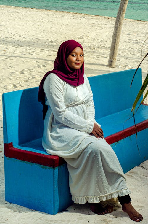 Woman Wearing Headscarf Sitting on a Beach
