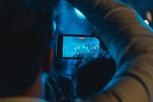 Man Recording a Concert in a Club 