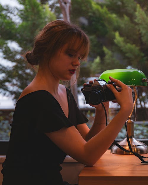 Woman Holding a Camera on a Beach 