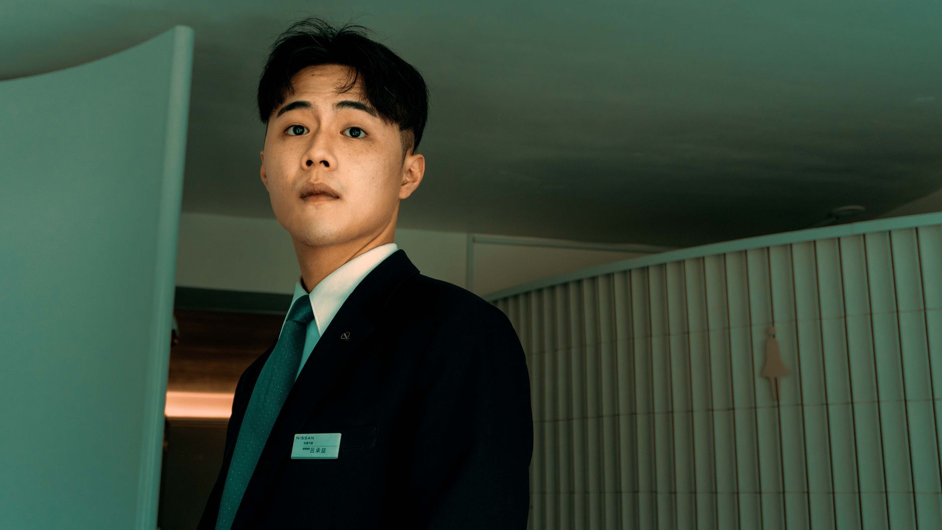 Portrait of a confident businessman in a suit indoors, facing forward.