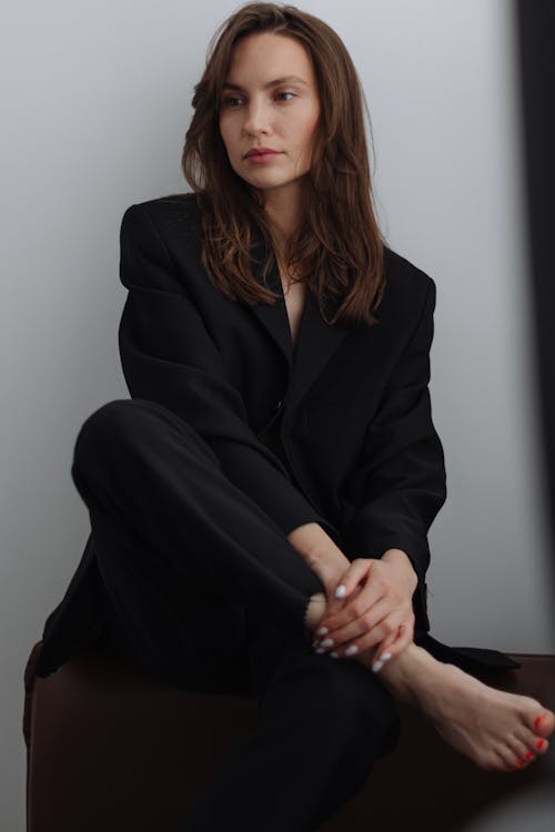 Woman in Black Suit Sitting and Posing