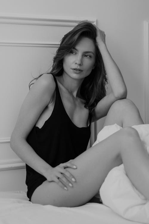A Woman in a Black Top Posing on the Bed