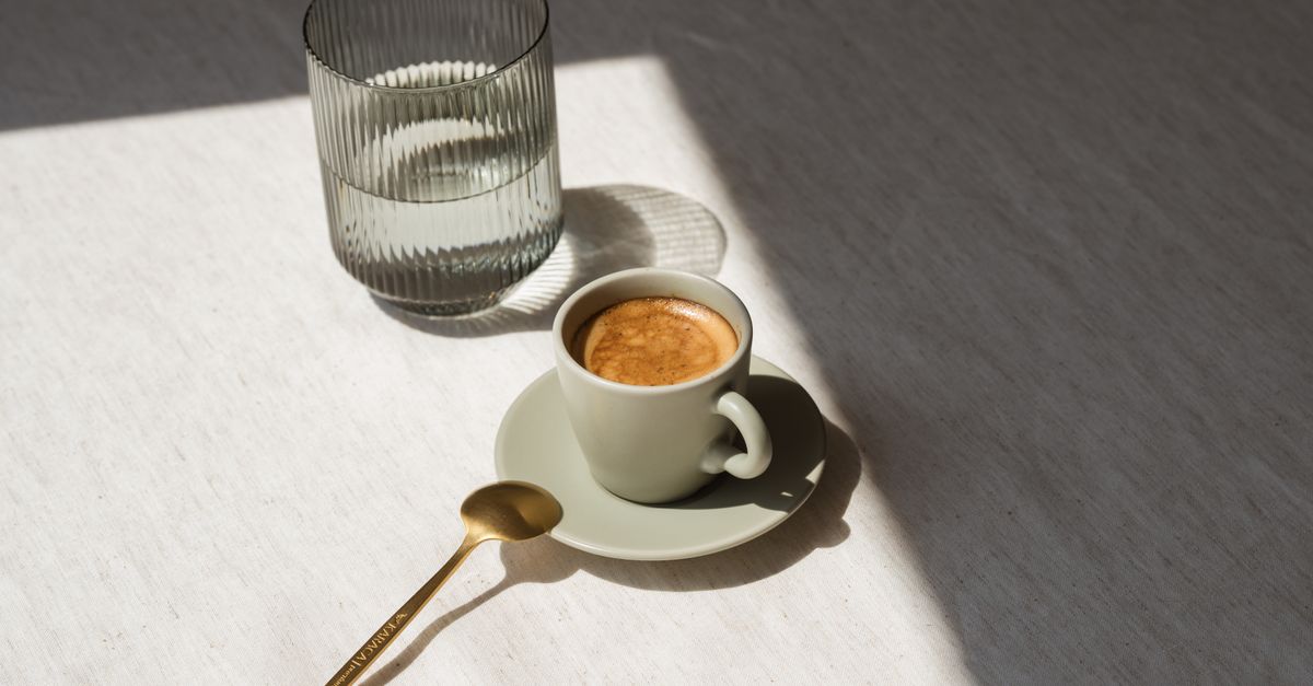 Espressokopje in warm ochtendzonlicht op een linnen kleed