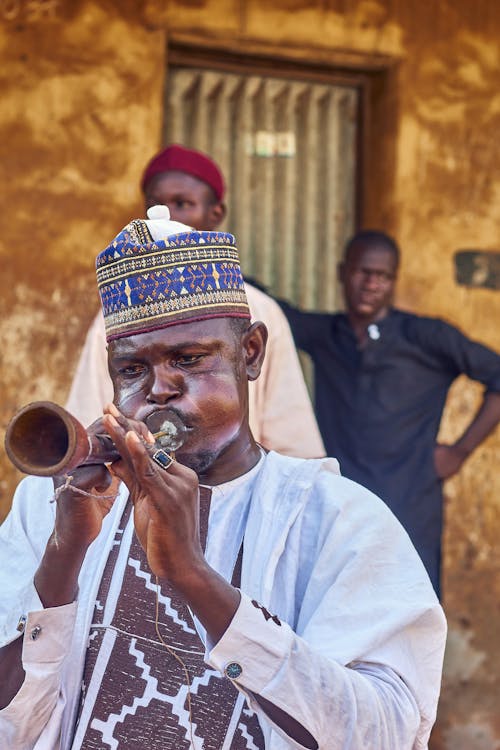 Man in Traditional Clothing Playing Trumpet