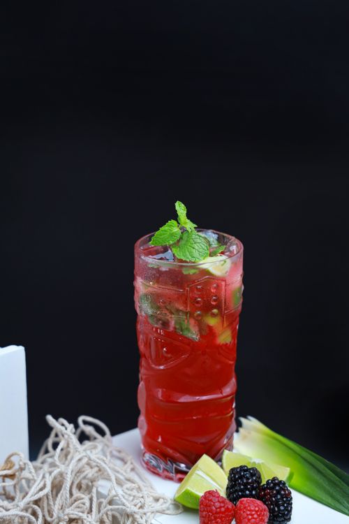 Free A vibrant glass of berry and mint drink with fresh lime slices, perfect for summer refreshment. Stock Photo