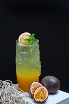 A vibrant passion fruit and citrus drink garnished with fresh mint leaves, perfect for a summer refreshment.