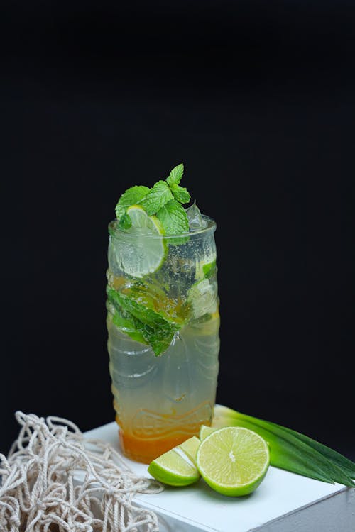 A glass of limeade with lime slices and mint leaves