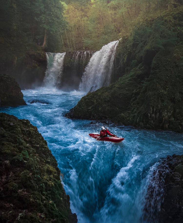 Person On Watercraft Near Waterfall