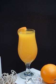 Chilled glass of fresh orange juice garnished with orange slice, perfect for a healthy lifestyle.
