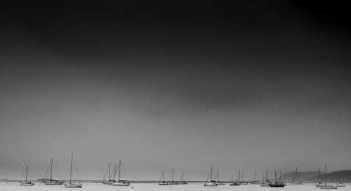 Monochrome boat harbor with dark sky