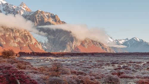 Free Majestic snow-capped mountains with vibrant autumn foliage and hoarfrost. Stock Photo