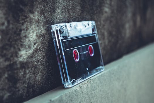 Close-up of a vintage cassette tape resting on a concrete surface, highlighting nostalgic audio technology.