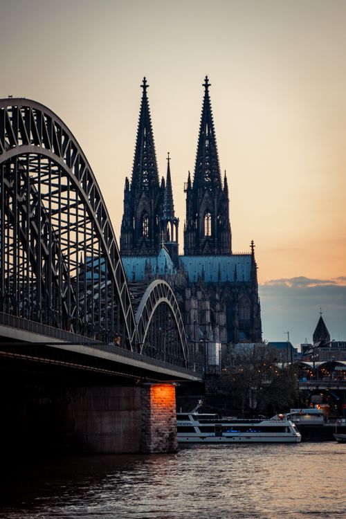 Free Stunning view of Cologne Cathedral with Hohenzollern Bridge at sunset. Stock Photo