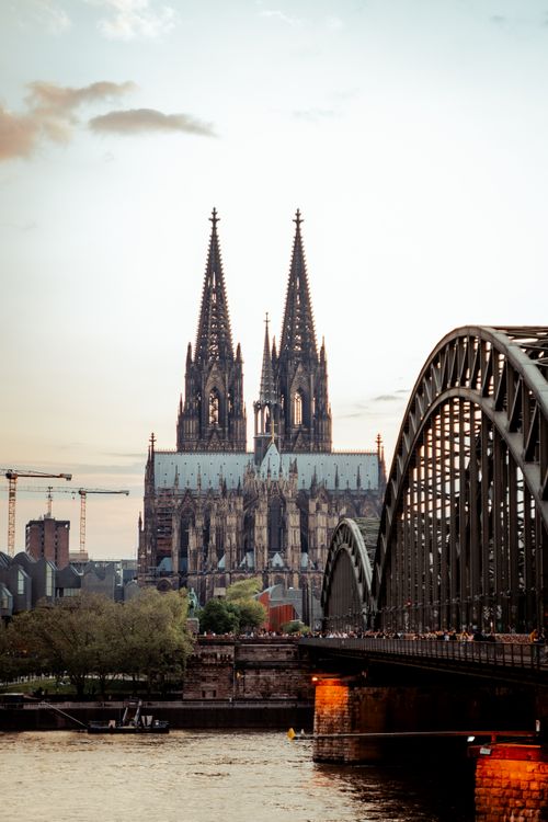 Free Iconic Gothic Cologne Cathedral and Hohenzollern Bridge in the evening, reflecting on the Rhine River. Stock Photo