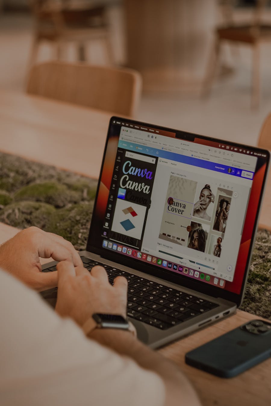 Close-up of a person using a laptop to design with Canva.