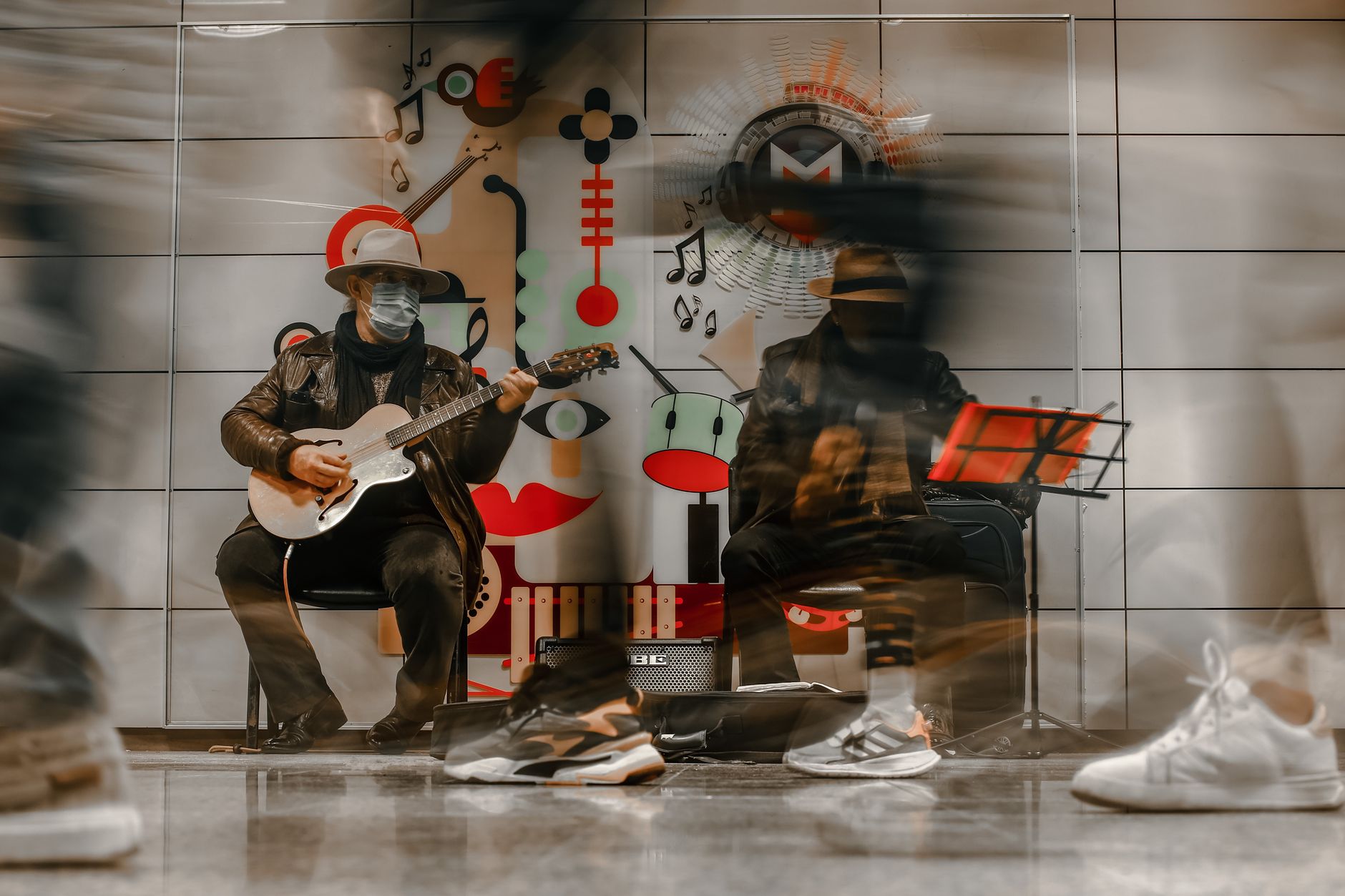 Dynamic street musicians play in an Istanbul metro station, surrounded by blurred motion.